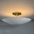 Wall-mounted light fixture with a gold base on a gray wall