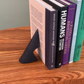 patinated brass bookend with books on wood table