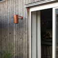 Wooden exterior wall with a sliding glass door opening to a kitchen.