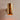 Brass cylindrical wall sconce on a beige wall