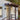 Porch with wooden roof and railing on a white house exterior with wall light