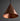 Copper pendant light against a dark background