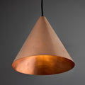 copper conical pendant in unpolished raw metal against a grey background with black cord