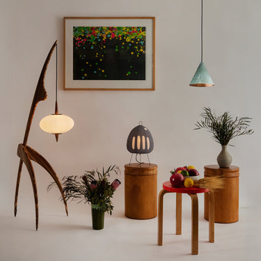Modern interior with wooden furniture, tratten and akari lighting, decorative items, and a colorful abstract painting on the wall.