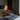 Modern bedroom with a bed, sofa, and lamp in a dimly lit room.
