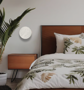 Bedroom with floral bedding, wooden headboard, and side table.