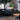 Modern interior with black leather chairs, a wooden table, and a large plant.