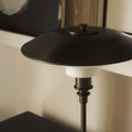 Black floor lamp with white base against a neutral background