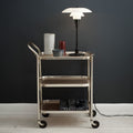 Cart with a lamp and decorative items against a dark wall