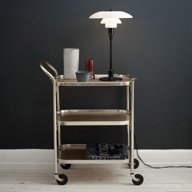 Cart with a lamp and decorative items against a dark wall