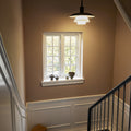 Stairwell with a window, light fixture, and small table.
