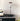 Modern table lamp on a black surface with a white background