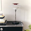 Modern table lamp on a black surface with a white background
