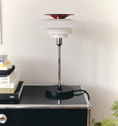 Modern table lamp on a black surface with a white background