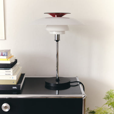Modern table lamp on a black surface with a white background