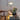 Chrome and glass table lamp on a desk with an open laptop and wood chair
