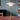 Table lamp with pink glass shade on a desk against a blue wall