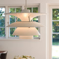 Modern white PH 5-4½ pendant light fixture in a room with windows showing greenery outside