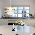 PH 5-4½ white Modern kitchen with a dining table featuring a vase of flowers and a candle.