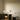 Panthella sizes of table lamps on black tables against a neutral wall.