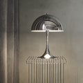 Modern silver chrome 1970s style table lamp with a textured shade on a neutral background