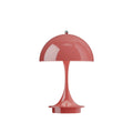 Red or coral colored 70s style table lamp on a white background