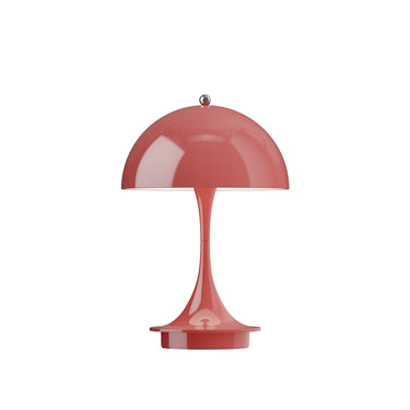 Red or coral colored 70s style table lamp on a white background