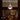 Pendant light fixture hanging above a wooden surface with decorative items.