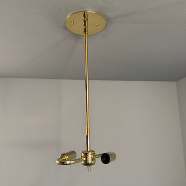 Gold wall-mounted lamp fixture on a plain white wall