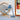 Blue desk lamp on a surface with a mirror and artwork in the background