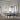 Modern dining room with white tables and chairs, pendant lights, and large windows.