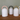 Five white ceramic lamps with colorful handles on a wooden surface.