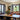 Dining room with a wooden table, chairs, and large windows.