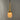 brass and glass pendant with a glowing tip on a gray background