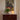 V3253 pale yellow conica table lamp artemide lit on midcentury credenza with a plant