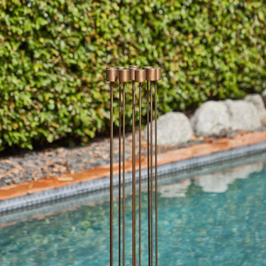 Decorative sculpture in a pool with greenery in the background