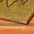 Close-up of a metal plate with embedded nails on a concrete surface detail of bertoia sculpture