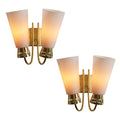 Two gold wall sconces with white lampshades on a white background