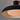 Close-up of a black pendant light with a warm glow on a gray background