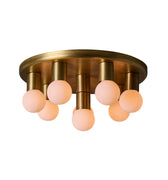 Brass ceiling light fixture with five round glass shades on a white background