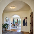 Archway leading into a room with wooden floor, gray rug, and decorative elements.