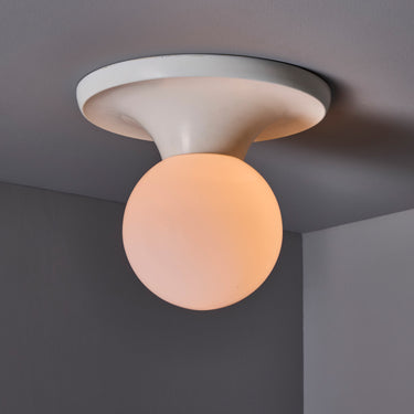 Ceiling light fixture with a spherical bulb on a gray ceiling
