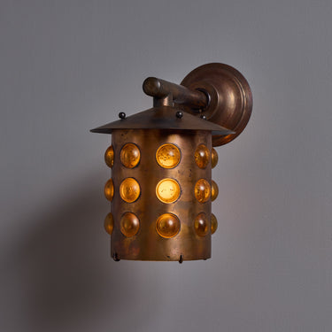 copper helena tynell glass bubble wall sconce with circular design on a gray background