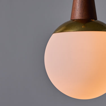 Close-up of a light pendant with a wooden base on a gray background