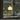 Table lamp with a warm glow on a windowsill with a view of greenery outside.