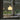 Table lamp with a warm glow on a windowsill with a view of greenery outside.