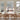 Dining area with wooden table and chairs in a room with large windows.