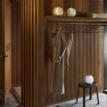 Wooden interior with hanging clothes and decorative portable glass VL45 lamps louis poulsen at two enlighten