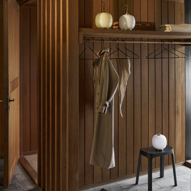 Wooden interior with hanging clothes and decorative portable glass VL45 lamps louis poulsen at two enlighten