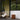Modern outdoor patio with wicker chair, hanging light, portable glass light and side table.